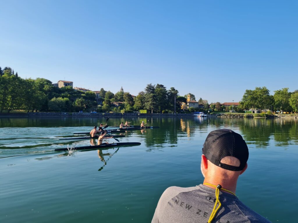 Coach watches on over calm lake as junior team trains